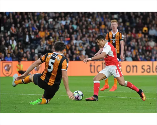Alexis Sanchez scores his 2nd goal for Arsenal beating Harry McGuire (Hull) on the way