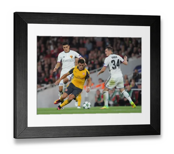 Framed Print : Arsenal's Alexis Sanchez vs. Mohamed Elyounoussi: Intense Face-Off in Arsenal vs. Basel UEFA Champions League Clash (2016-17) Framed Print : Arsenal's Alexis Sanchez vs. Mohamed Elyounoussi: Intense Face-Off in Arsenal vs. Basel UEFA Champions League Clash (2016-17)