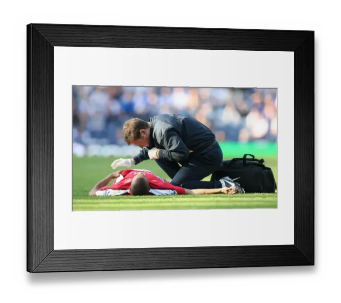 Framed Print : Arsenal physio Colin Lewin treats the injured Gael Clichy Framed Print : Arsenal physio Colin Lewin treats the injured Gael Clichy