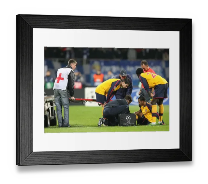 Framed Print : Injured Theo Walcott is treated by Arsenal physio Colin Lewin