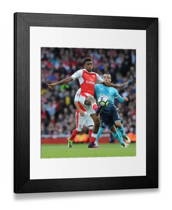 Framed Print : Arsenal's Iwobi Goes Head-to-Head with Swansea's Britton in Premier League Showdown Framed Print : Arsenal's Iwobi Goes Head-to-Head with Swansea's Britton in Premier League Showdown