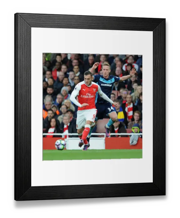 Framed Print : Arsenal's Lucas Perez Clashes with Middlesbrough's Adam Forshaw in Premier League Showdown