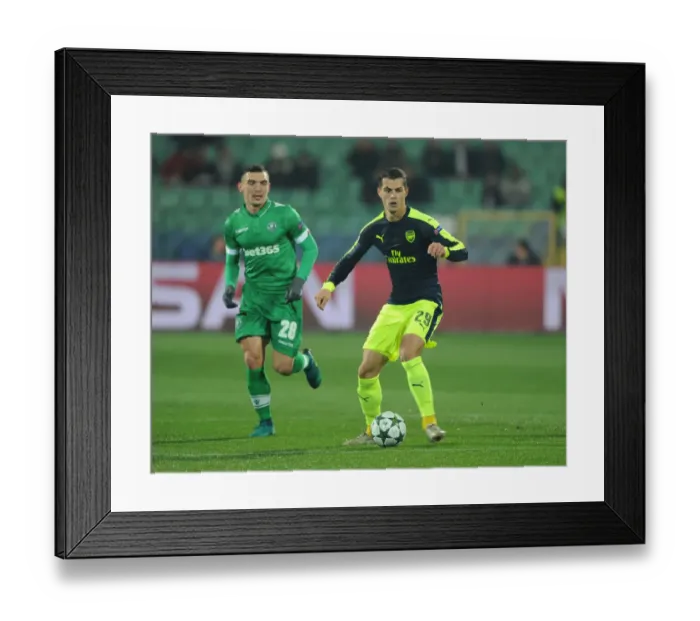Framed Print : Granit Xhaka Breaks Past Ludogorets Claudiu Keseru in Arsenal's UEFA Champions League Clash