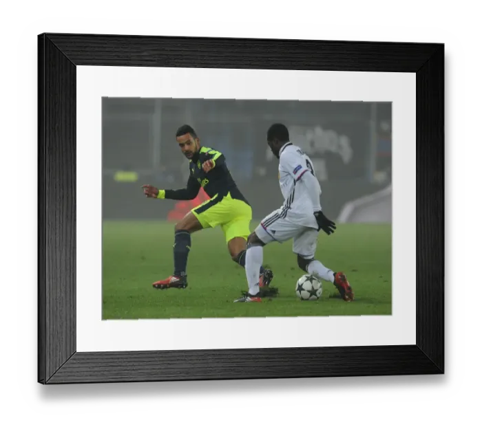 Framed Print : Theo Walcott vs Adama Traore: Clash in the UEFA Champions League between FC Basel and Arsenal