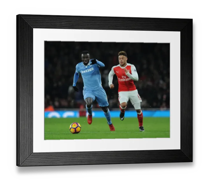 Framed Print : Fierce Rivalry: Oxlade-Chamberlain vs. Diouf Clash at Arsenal v Stoke City (2016-17)