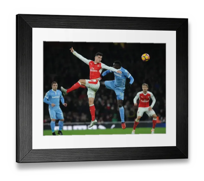 Framed Print : Xhaka vs Diouf: Heading Battle at Emirates Stadium - Arsenal vs Stoke City, Premier League 2016-17