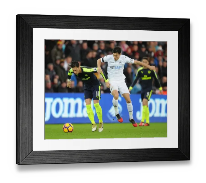 Framed Print : Mesut Ozil vs Jack Cork: A Premier League Showdown at Swansea City