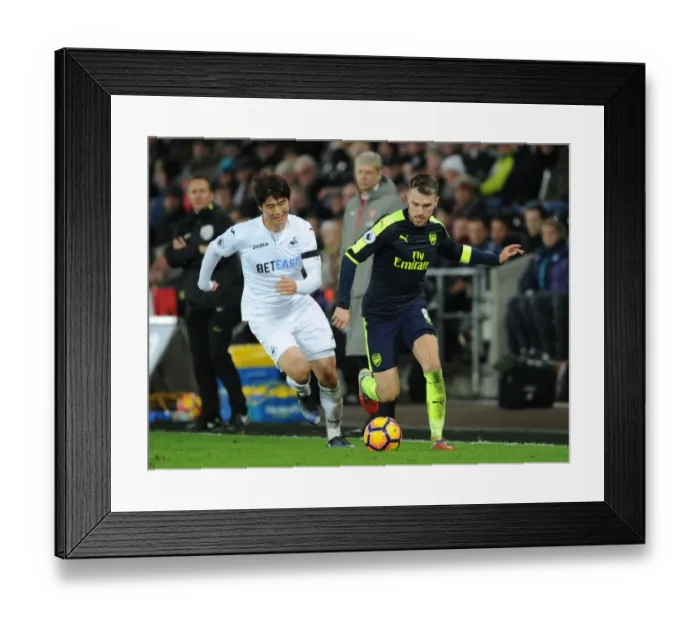 Framed Print : Arsenal's Aaron Ramsey Outmaneuvers Swansea's Ki Sung-Yueng in Premier League Clash