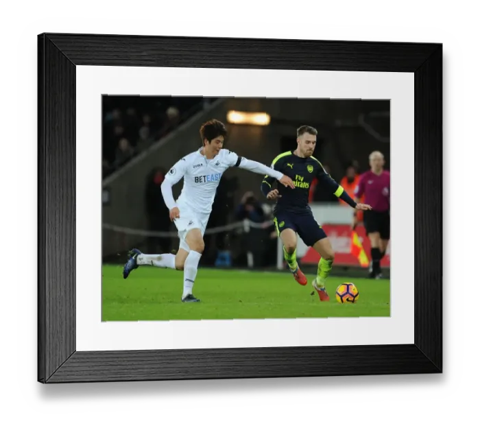 Framed Print : Arsenal's Aaron Ramsey Outwits Ki Sung-Yueng in Premier League Clash