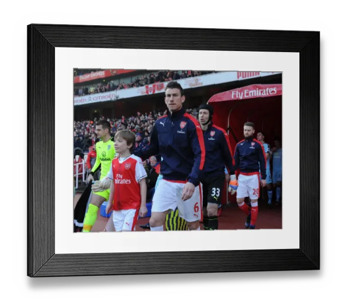 Framed Print : Laurent Koscielny (Arsenal) with the mascot before the match. Arsenal 2: 1 Burnley