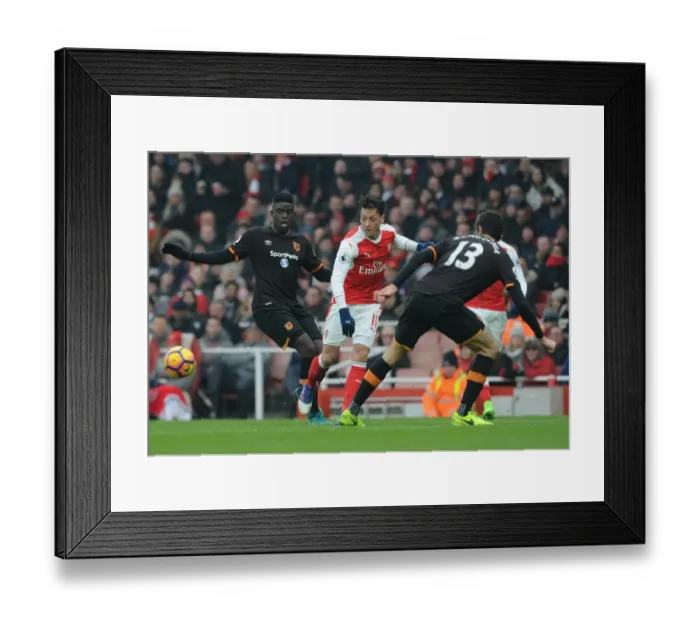 Framed Print : Arsenal's Ozil Evades Defenders in Intense Arsenal v Hull City Premier League Clash
