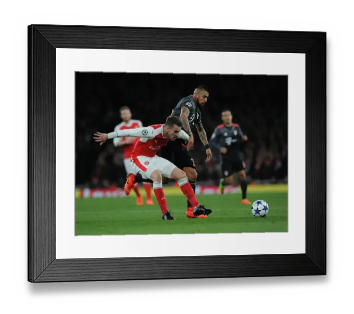 Framed Print : Arsenal's Ramsey vs Bayern's Vidal: Battle in the UEFA Champions League