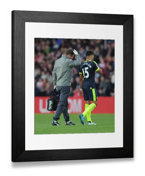 Framed Print : Alex Oxlade-Chamberlain Receives Treatment from Physio Colin Lewin during Southampton Match, 2017