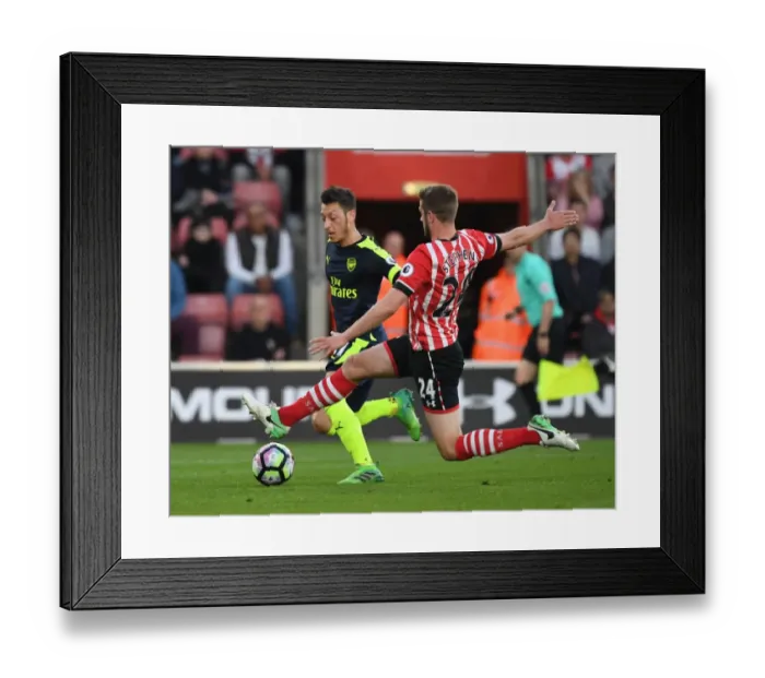 Framed Print : Mesut Ozil vs Jack Stephens: Intense Battle in Southampton v Arsenal Premier League Clash Framed Print : Mesut Ozil vs Jack Stephens: Intense Battle in Southampton v Arsenal Premier League Clash
