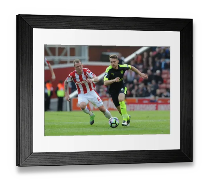 Framed Print : Aron Ramsey vs. Glenn Whelan: Intense Battle in Stoke City vs. Arsenal Premier League Clash