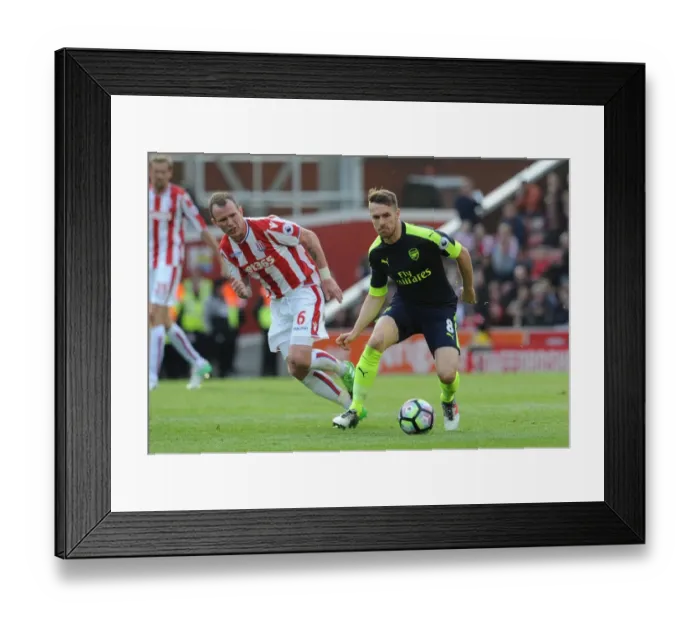 Framed Print : Ramsey vs. Whelan: Intense Battle in Stoke City vs. Arsenal Premier League Clash