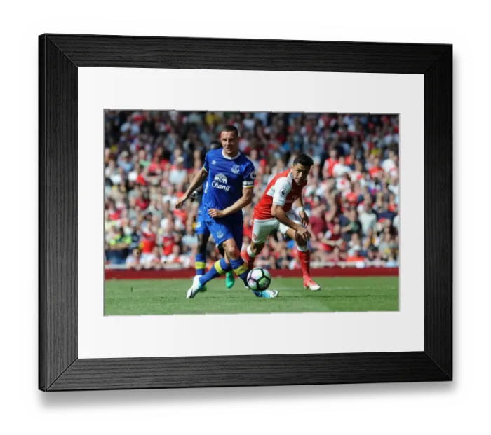 Framed Print : Arsenal's Alexis Sanchez Fouls by Everton's Phil Jagielka in Intense Premier League Clash Framed Print : Arsenal's Alexis Sanchez Fouls by Everton's Phil Jagielka in Intense Premier League Clash