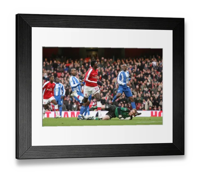 Framed Print : Emmanual Adebayor shoots past Wigan goalkeeper Chris Framed Print : Emmanual Adebayor shoots past Wigan goalkeeper Chris