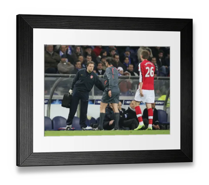 Framed Print : Arsenal physio Colin Lewin attempts to treat Nicklas Bendtner