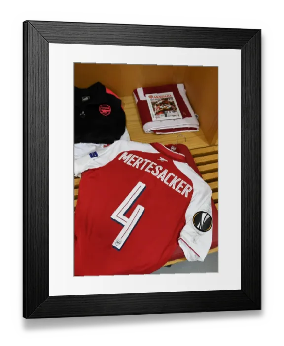 Framed Print : Per Mertesacker's Arsenal Shirt and Pennant in Arsenal's Changing Room (Arsenal v FC Köln, 2017-18)