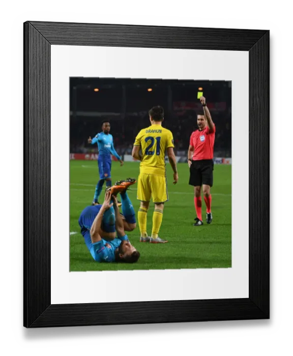 Framed Print : Arsenal's Mustafi Fouls BATE's Dragun: Referees Yellow Card in Europa League Clash Framed Print : Arsenal's Mustafi Fouls BATE's Dragun: Referees Yellow Card in Europa League Clash