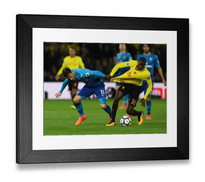 Framed Print : Mesut Ozil vs. Abdouaye Doucoure: A Midfield Showdown at Vicarage Road