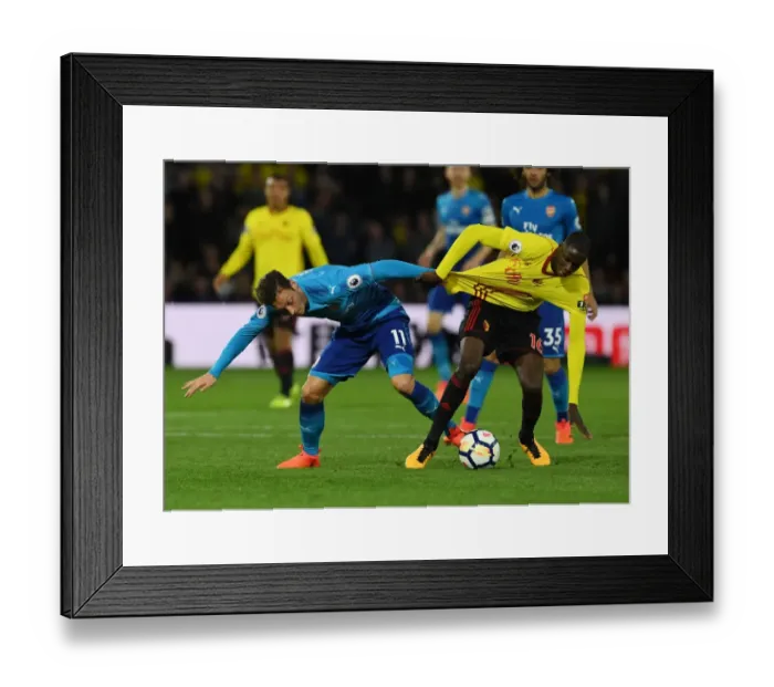 Framed Print : Clash on the Pitch: Ozil vs. Doucoure in the Premier League Battle between Watford and Arsenal Framed Print : Clash on the Pitch: Ozil vs. Doucoure in the Premier League Battle between Watford and Arsenal