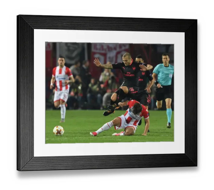Framed Print : Jack Wilshere Leaps Over Filip Stojkovic in Europa League Clash between Crvena Zvezda and Arsenal Framed Print : Jack Wilshere Leaps Over Filip Stojkovic in Europa League Clash between Crvena Zvezda and Arsenal