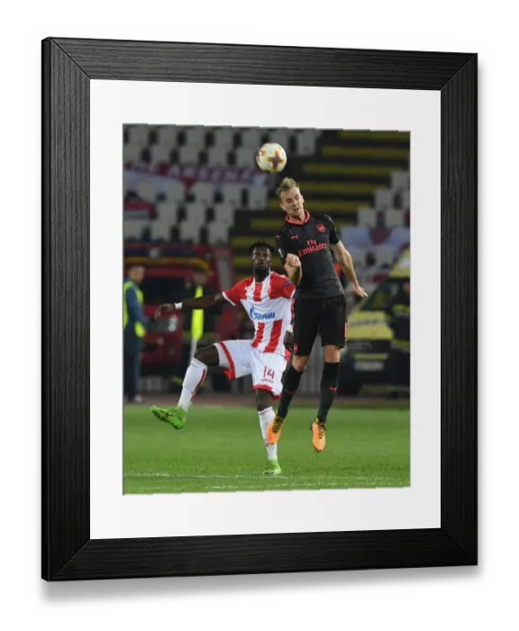 Framed Print : Rob Holding Leaps Over Richmond Boakye in Europa League Clash between Crvena Zvezda and Arsenal Framed Print : Rob Holding Leaps Over Richmond Boakye in Europa League Clash between Crvena Zvezda and Arsenal