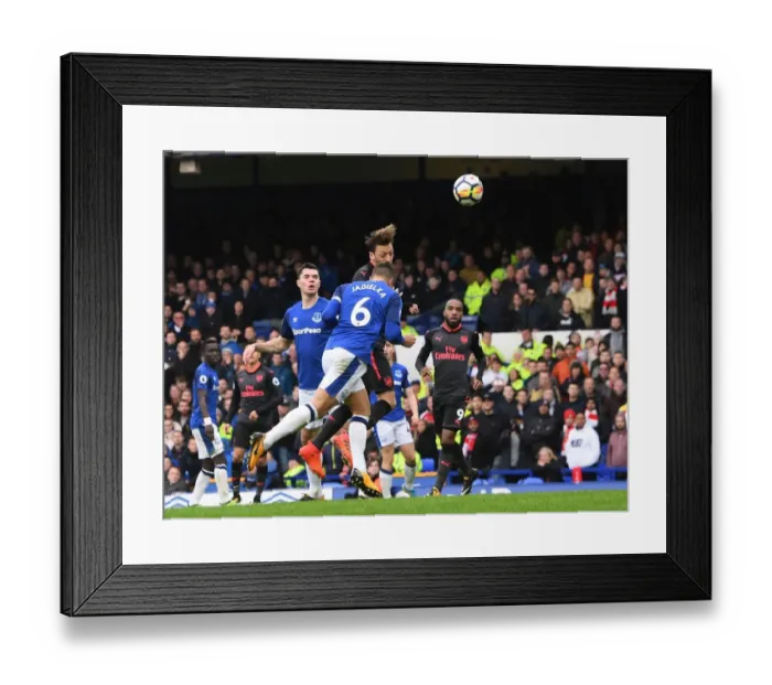 Framed Print : Mesut Ozil Scores Under Pressure: A Intense Moment from Everton vs Arsenal, Premier League 2017-18 - Ozil's Goal Amidst Jagielka's Challenge