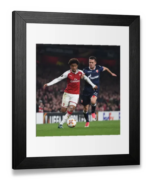 Framed Print : Reiss Nelson vs Marko Gobeljic: A Battle in the Europa League - Arsenal FC vs Crvena Zvezda