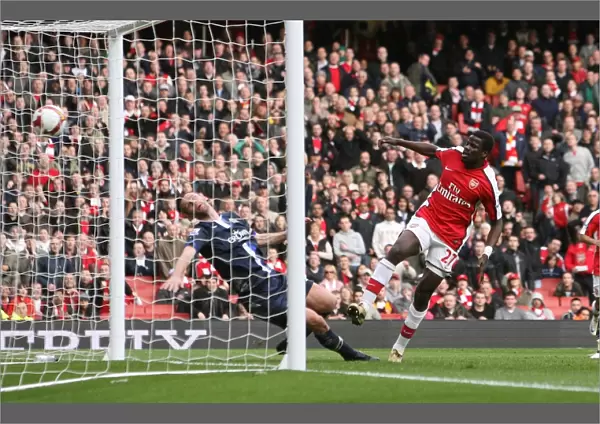 Emmanuel Eboue shoots past Andre Ooijer to score the 3rd Arsenal goal