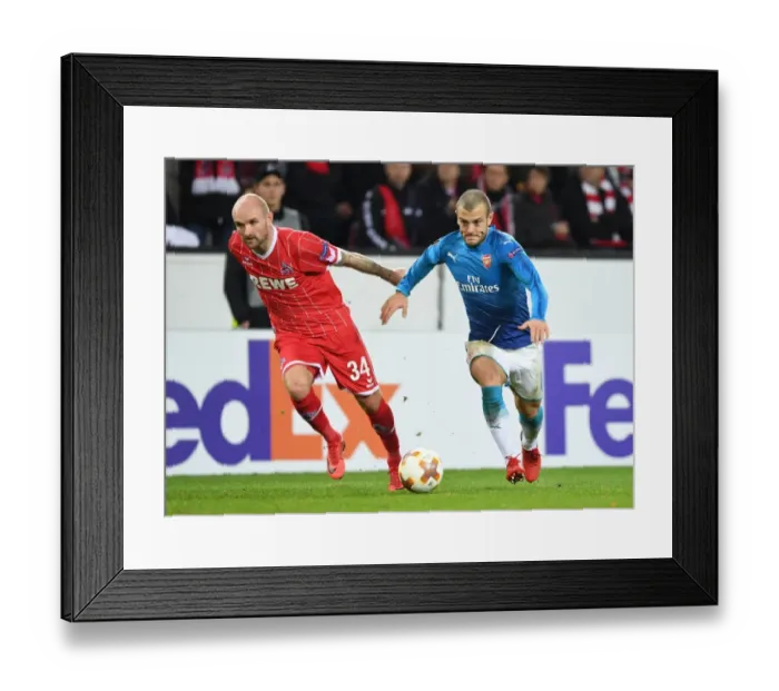 Framed Print : Wilshere vs. Rausch: A Europa League Battle - Arsenal's Jack Wilshere Goes Head-to-Head with FC Koln's Konstanin Rausch Framed Print : Wilshere vs. Rausch: A Europa League Battle - Arsenal's Jack Wilshere Goes Head-to-Head with FC Koln's Konstanin Rausch