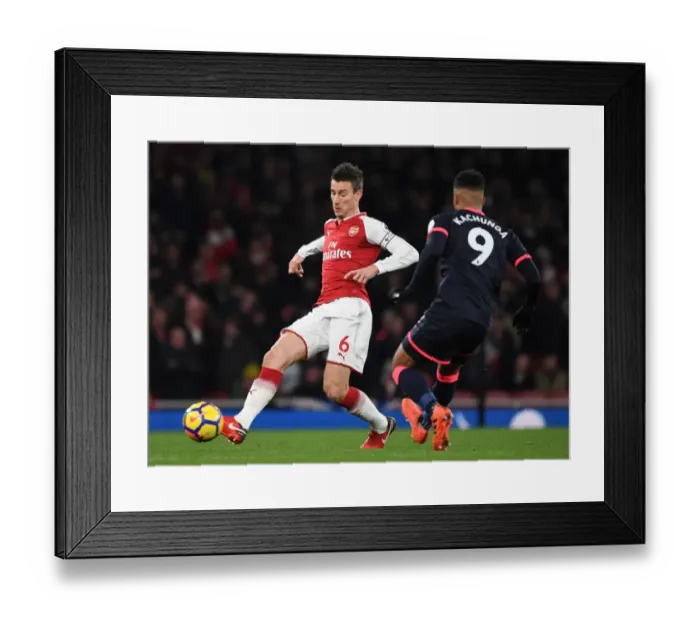 Framed Print : Arsenal's Koscielny Clashes with Huddersfield's Kachunga in Premier League Showdown Framed Print : Arsenal's Koscielny Clashes with Huddersfield's Kachunga in Premier League Showdown