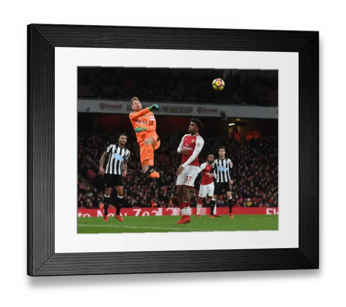Framed Print : Arsenal's Alex Iwobi Challenges Newcastle's Rob Elliot in Premier League Clash