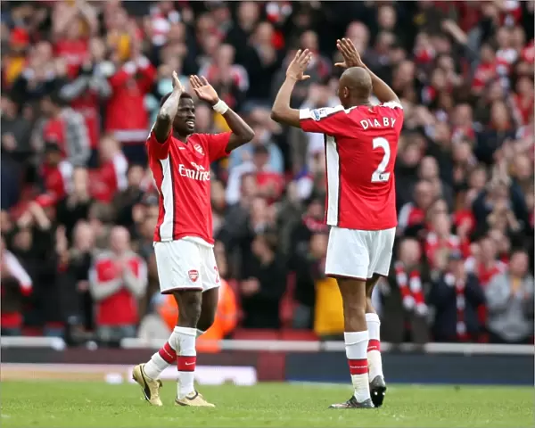 Emmanuel Eboue celebrates at the end of the match with Abou Diaby