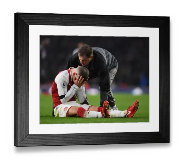 Framed Print : Arsenal's Jack Wilshere Receives Medical Attention from Physio Colin Lewin during Premier League Match Framed Print : Arsenal's Jack Wilshere Receives Medical Attention from Physio Colin Lewin during Premier League Match