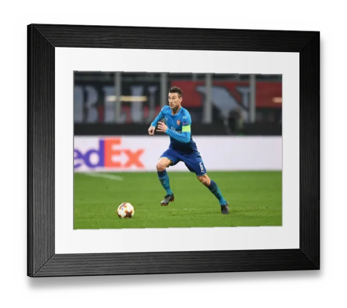 Framed Print : Focused Koscielny: Arsenal's Defensive Hero in Europa League Clash Against AC Milan Framed Print : Focused Koscielny: Arsenal's Defensive Hero in Europa League Clash Against AC Milan
