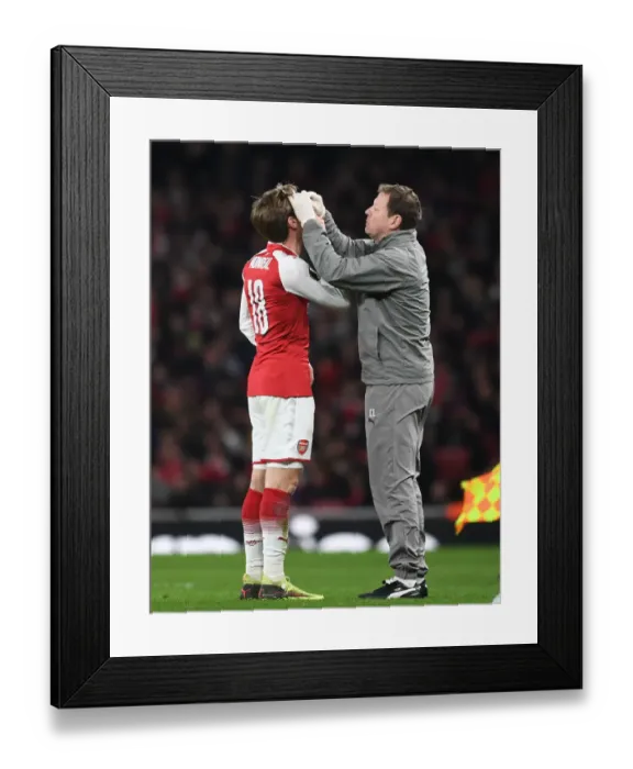 Framed Print : Nacho Monreal Receives Treatment from Arsenal Physio Colin Lewin during Arsenal v AC Milan Europa League Clash Framed Print : Nacho Monreal Receives Treatment from Arsenal Physio Colin Lewin during Arsenal v AC Milan Europa League Clash