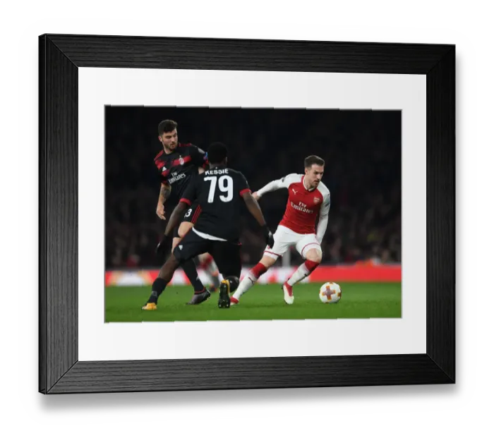 Framed Print : Arsenal's Ramsey Stands Firm Against Milan's Cutrone and Kessie in Europa League Showdown Framed Print : Arsenal's Ramsey Stands Firm Against Milan's Cutrone and Kessie in Europa League Showdown