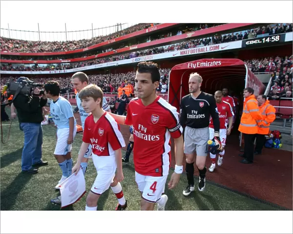 Cesc Fabregas and Manuel Almunia lead out Arsenal