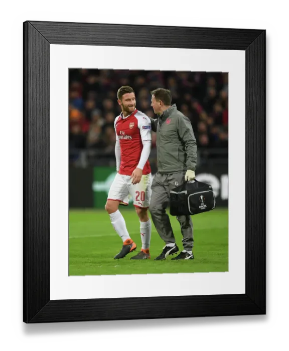 Framed Print : Shkodran Mustafi Receives Treatment from Arsenal Physio Colin Lewin during CSKA Moscow vs Arsenal UEFA Europa League Match