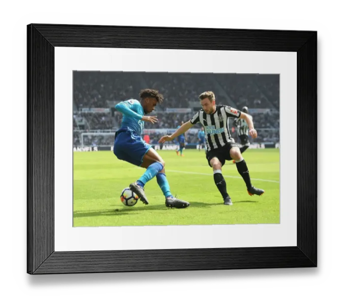 Framed Print : Arsenal's Alex Iwobi Outmaneuvers Newcastle's Paul Dummett in Intense Premier League Clash
