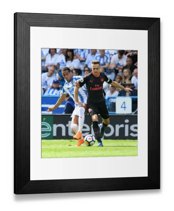 Framed Print : Arsenal's Aaron Ramsey Faces Off Against Huddersfield's Tom Ince in Premier League Clash