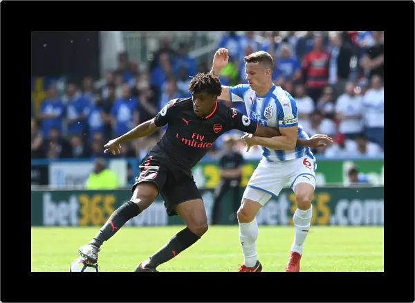 Arsenal's Alex Iwobi Fends Off Huddersfield's Jonathan Hogg During Premier League Clash
