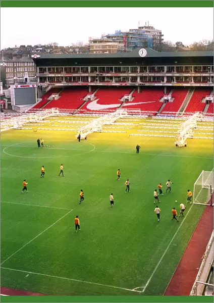 The Arsenal team train on the pitch at Highbury