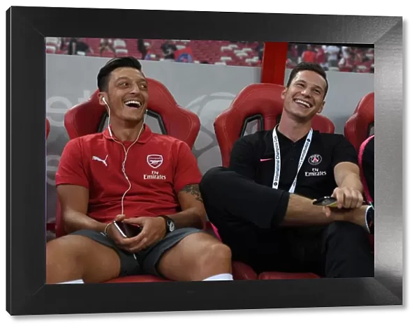 Arsenal's Ozil and Draxler Engage in Pre-Match Chat Ahead of Arsenal vs. Paris Saint-Germain