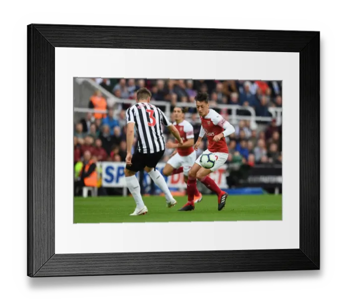 Framed Print : Mesut Ozil and Paul Dummett Clash in Intense Arsenal Victory over Newcastle United at St. James Park (1:2)