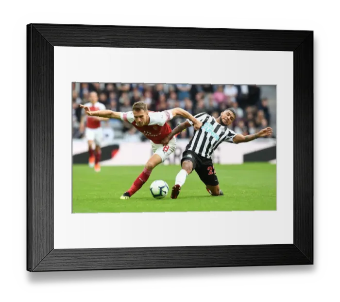 Framed Print : Aaron Ramsey vs Kenedy: Intense Battle in Newcastle United vs Arsenal FC Premier League Clash Framed Print : Aaron Ramsey vs Kenedy: Intense Battle in Newcastle United vs Arsenal FC Premier League Clash