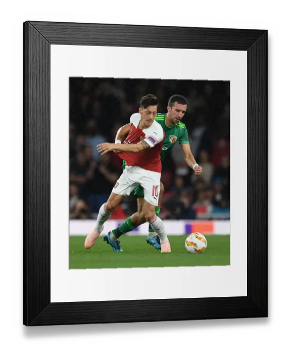 Framed Print : Arsenal's Mesut Ozil Clashes with Vyacheslav Sharpar of Vorskla Poltava in Europa League Match